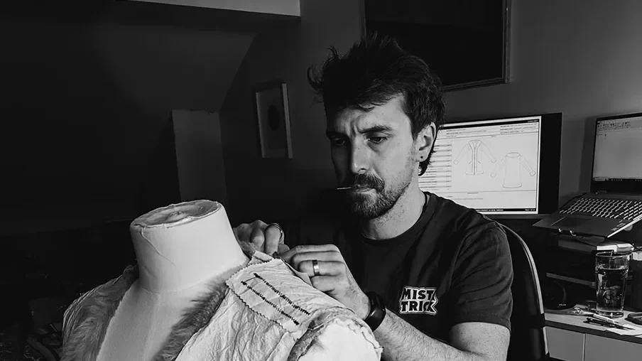 A Revel Threads tailor is carefully crafting the next festival coat