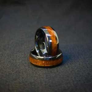 Midnight Grain Ring shadow-lit angle, black ceramic base, wood grain finish, reflective surface