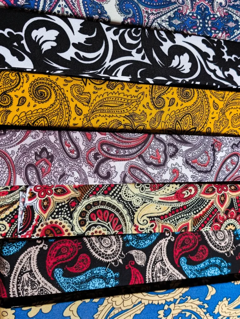 Close-up of colourful paisley and patterned fabric designs used for Revel Threads guitar straps.